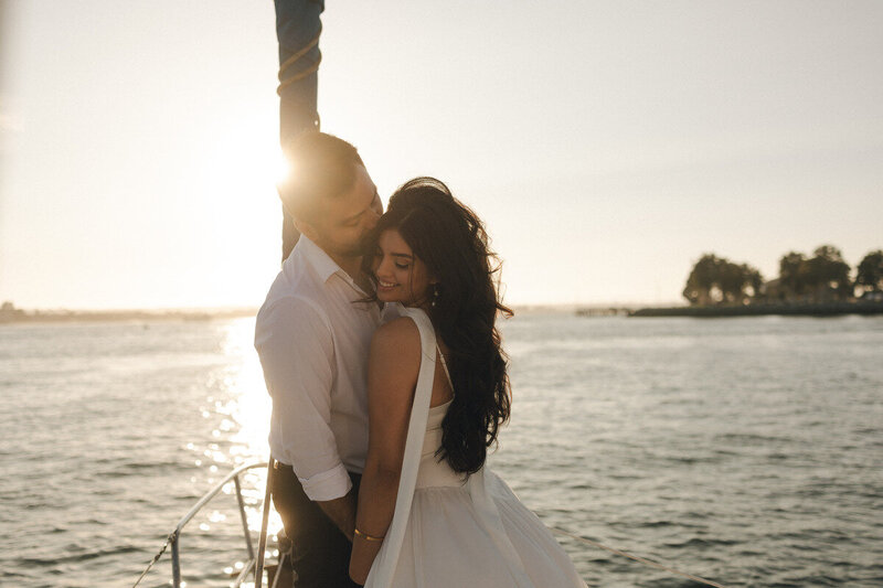 Bride and groom on sailboat at golden hour, romantic destination elopement photography on the West Coast by Tarah Shea