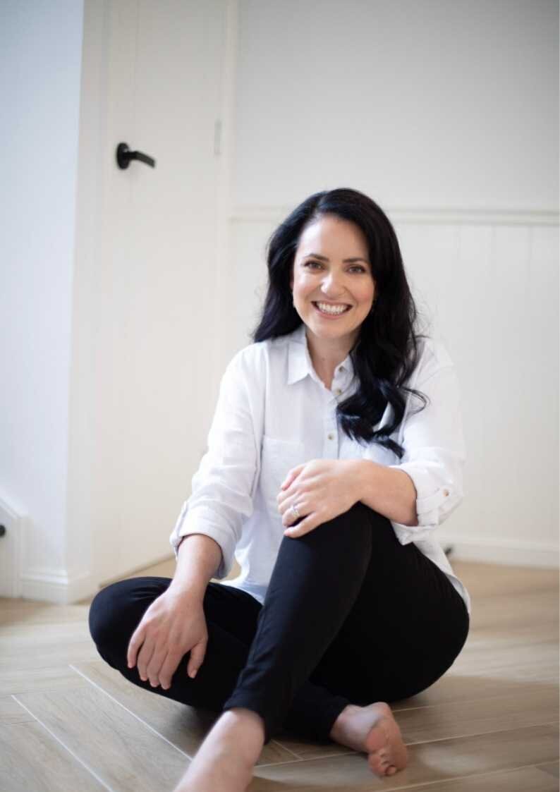 Leading Australian eCommerce business coach and marketing strategist for female product-based businesses Kristy Dinuzzo sitting on floor with feet crossed