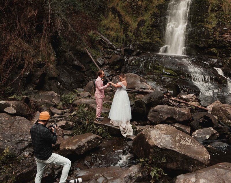 Photographer Peter Ali shooting an elopement in front of a waterfall