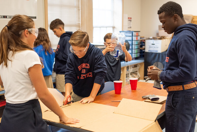 Students in a classroom collaborate candidly in a branding image