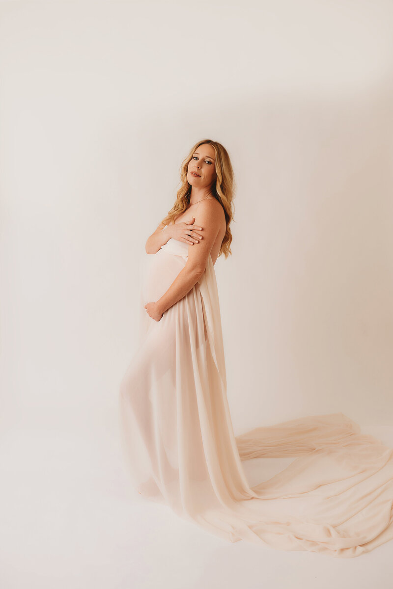 Pregnant woman embraces her pregnant belly during Maternity Pictures in Charleston, South Carolina.