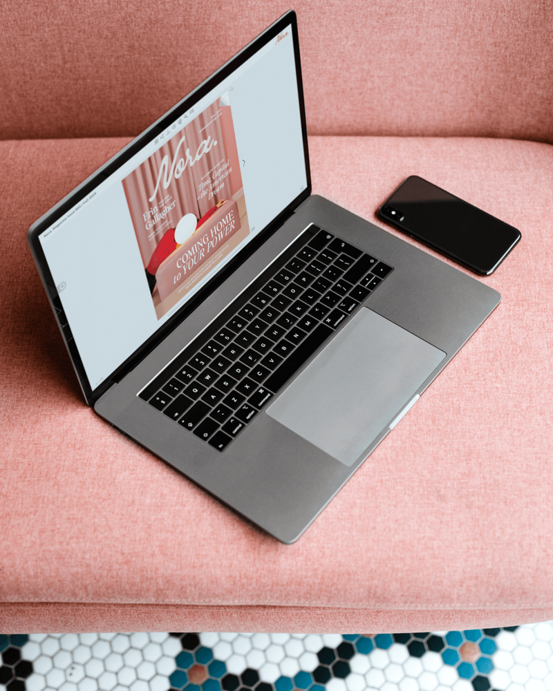 Laptop sitting on couch with screen showing the cover of the Fall issue of Nora. Magazine for female founders.