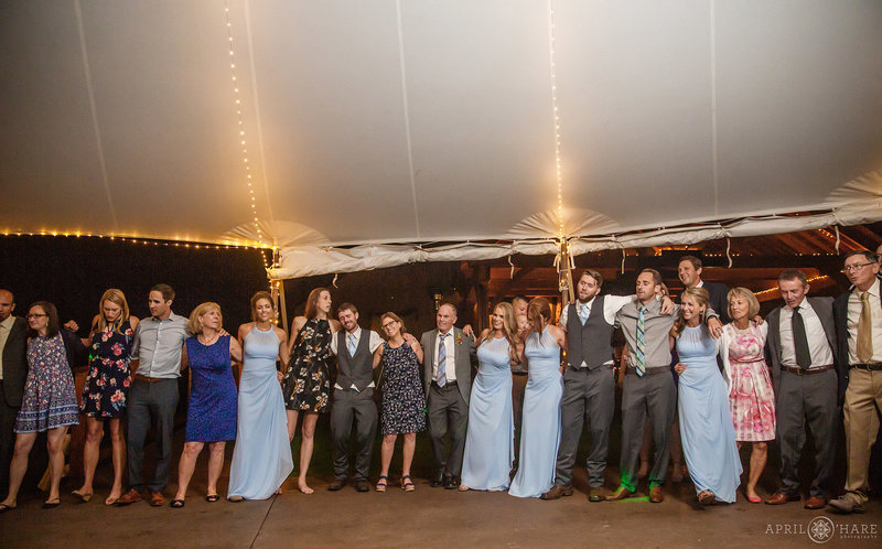 Wedding guests sing in a large circle at Blackstone Rivers Ranch wedding reception