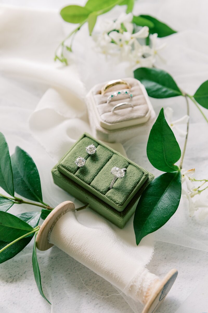 an engagement ring and bridal earrings in a green jewelry box