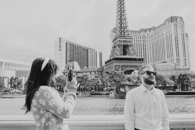 Person points film camera at partner in front of Las Vegas Eiffel tower