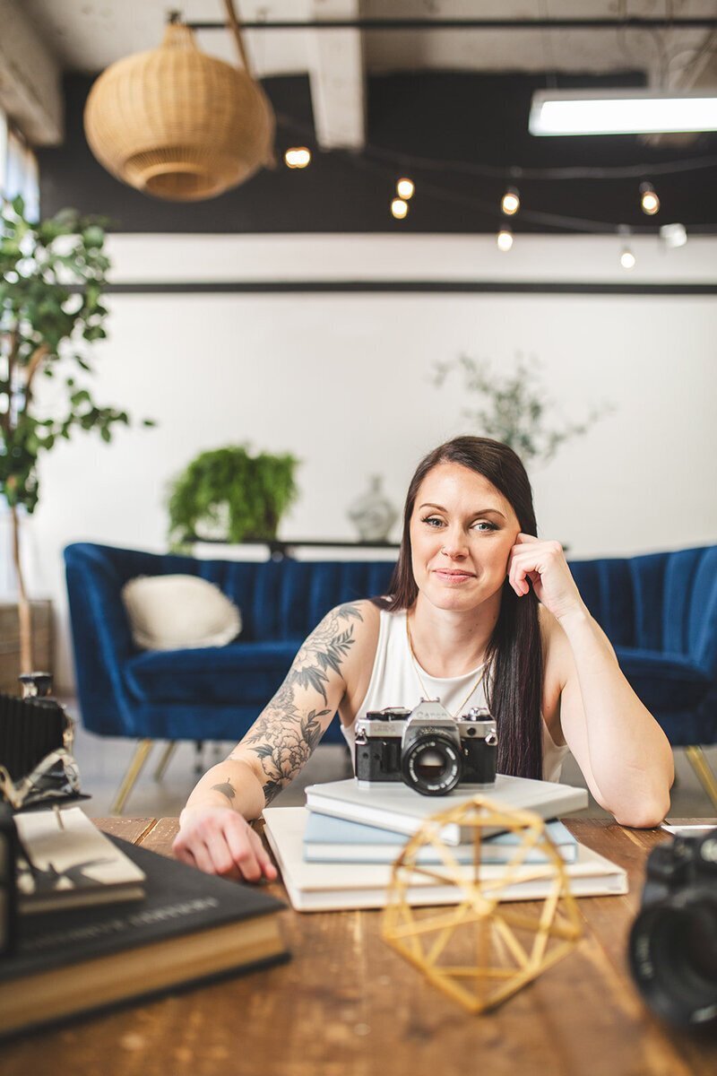 baltimore wedding photographer Nicole Simensky with her camera and albums