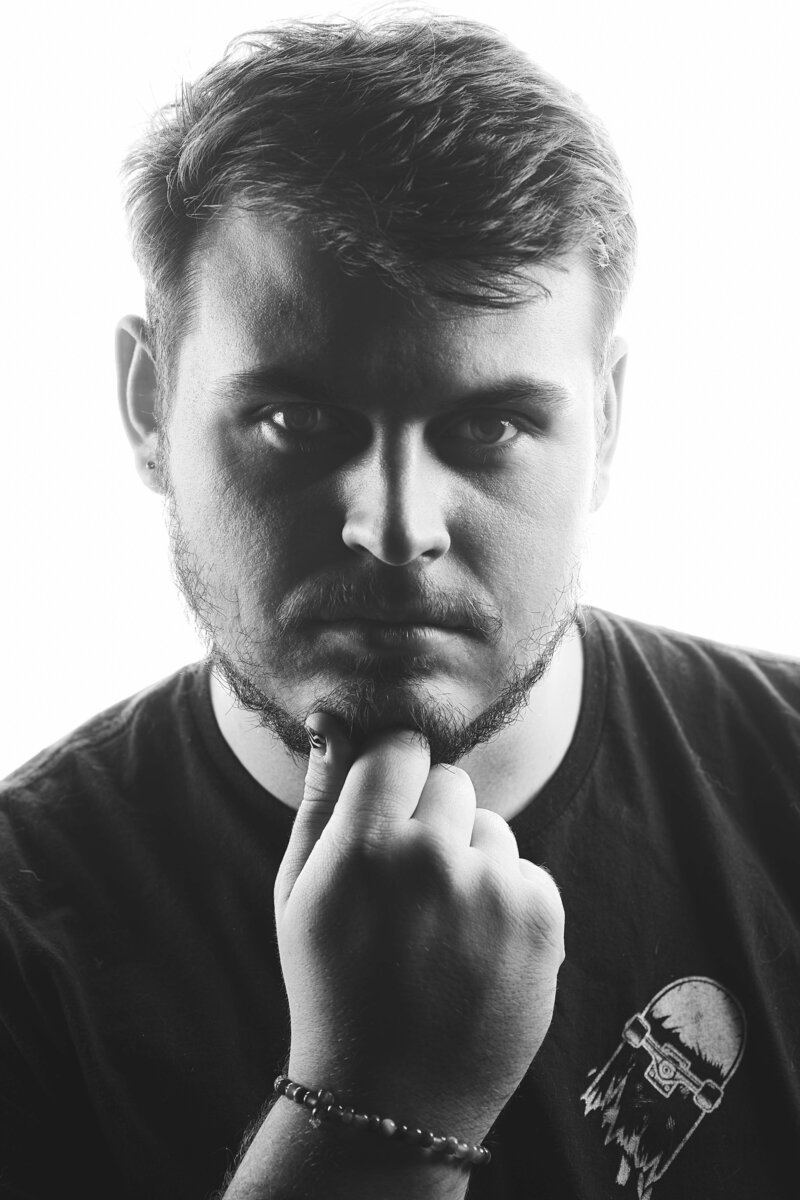 charlie is staring at the camera with a serious face holding his hand by his chin
