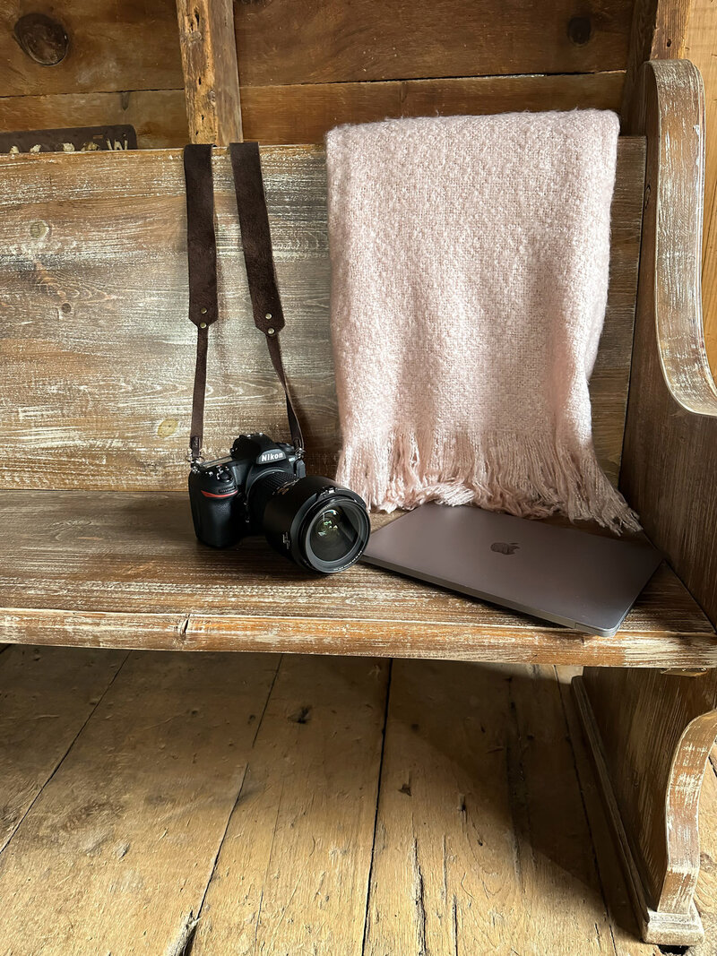 Camera sitting on bench next to lap top