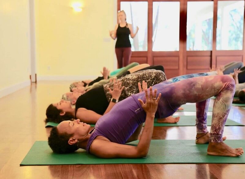Student demonstrating bridge pose with proper alignment cues.