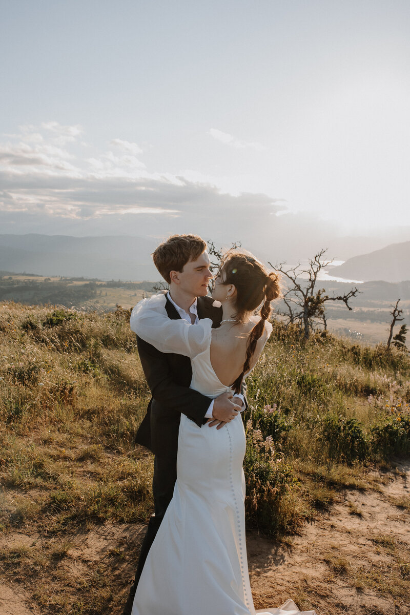 Bride and groom dancing on a grassy mountain top