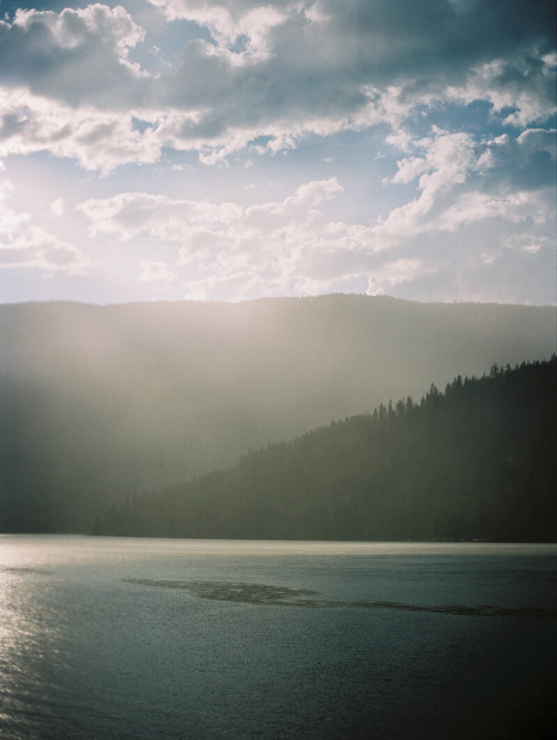 A serene lake reflecting the surrounding mountains, creating a peaceful atmosphere that connects to nature’s restorative power and holistic wellness.