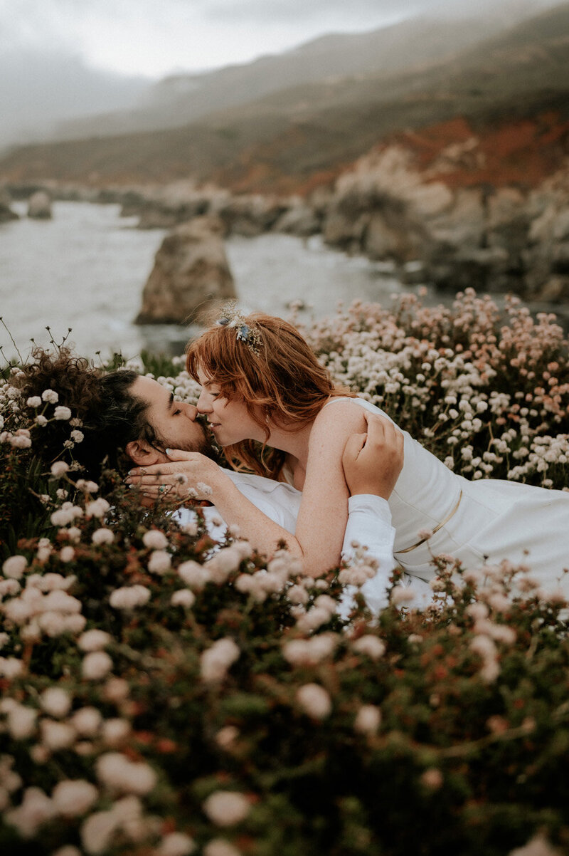 Elopement Photography, couple laying down in flowers about to kiss