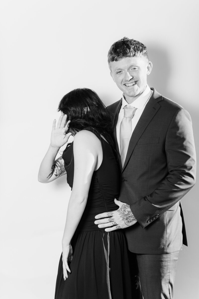 Candid black and white portrait of a couple laughing and sharing a playful moment at a Vogue Portrait photo booth in Richmond, VA.