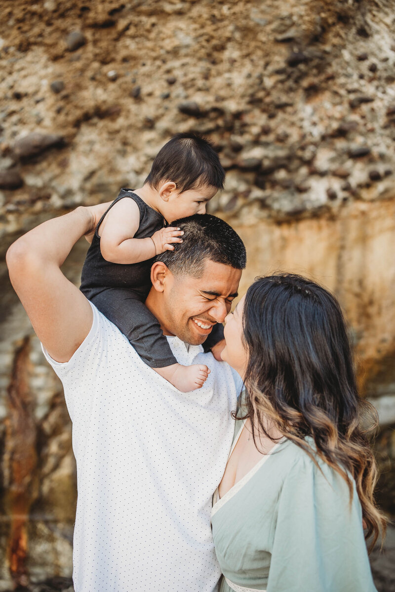 son trying to eat dads hair during family photoshoot