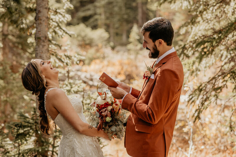 Couple laughing while reading their vows.