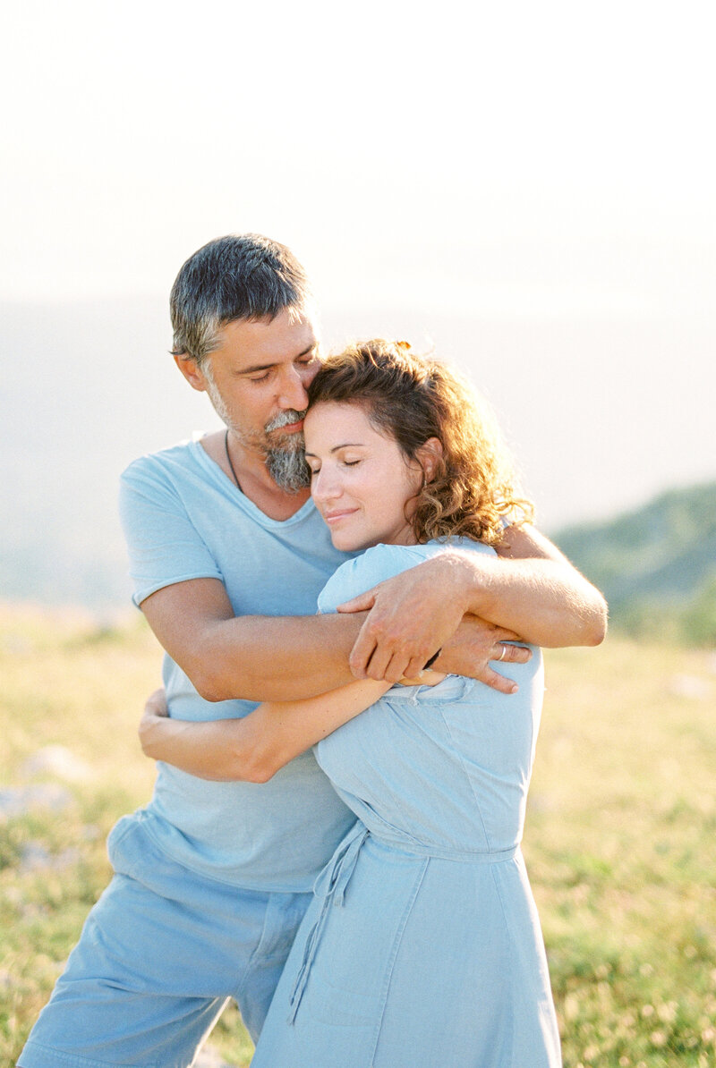 Loving couple embracing in soft natural light during sunset on a hill, photographed by Toronto wedding photographer