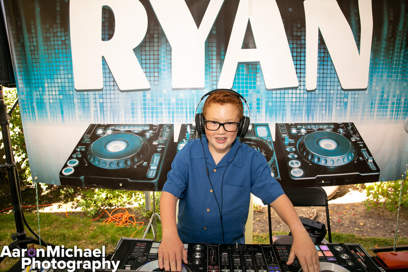 Young boy DJing with headphones and gear