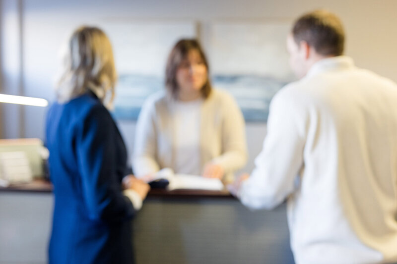 Heather chatting with clients at the front desk