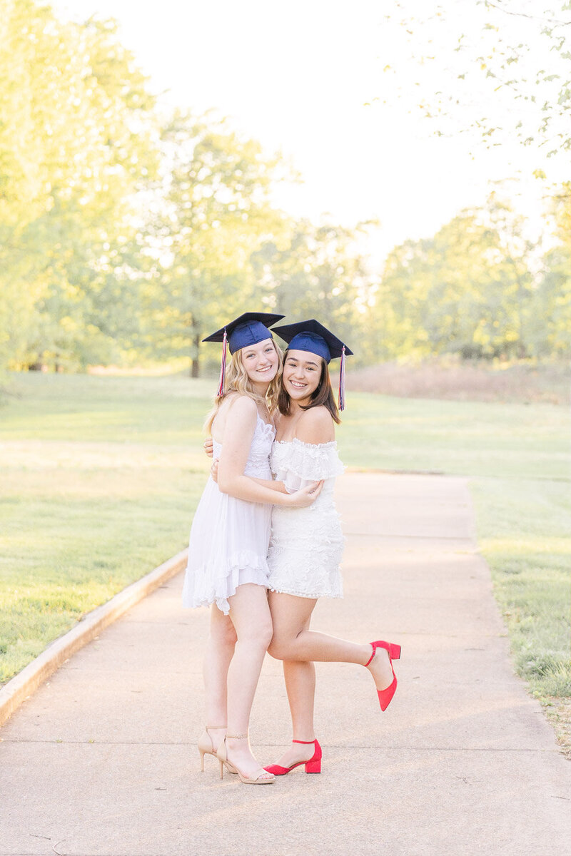 senior best friends wearing graduation cap hugging each other during senior photography in Loudoun County, VA