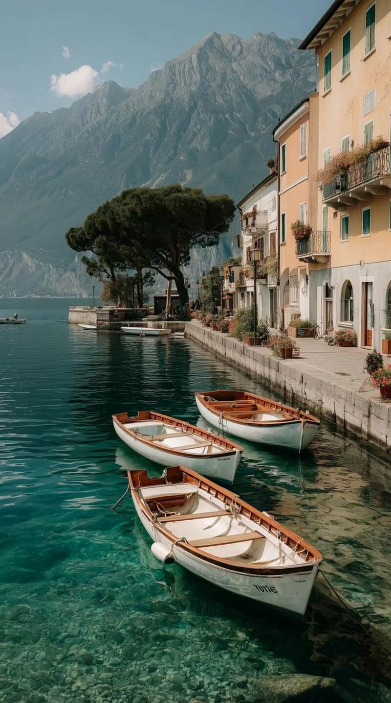 Scenic Lake Como view with traditional wooden boats, charming architecture, and dramatic mountains. The perfect destination for making mutliple stops along the way.