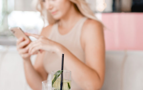 Out of focused photo of Hollie looking at phone while sitting at restaurant
