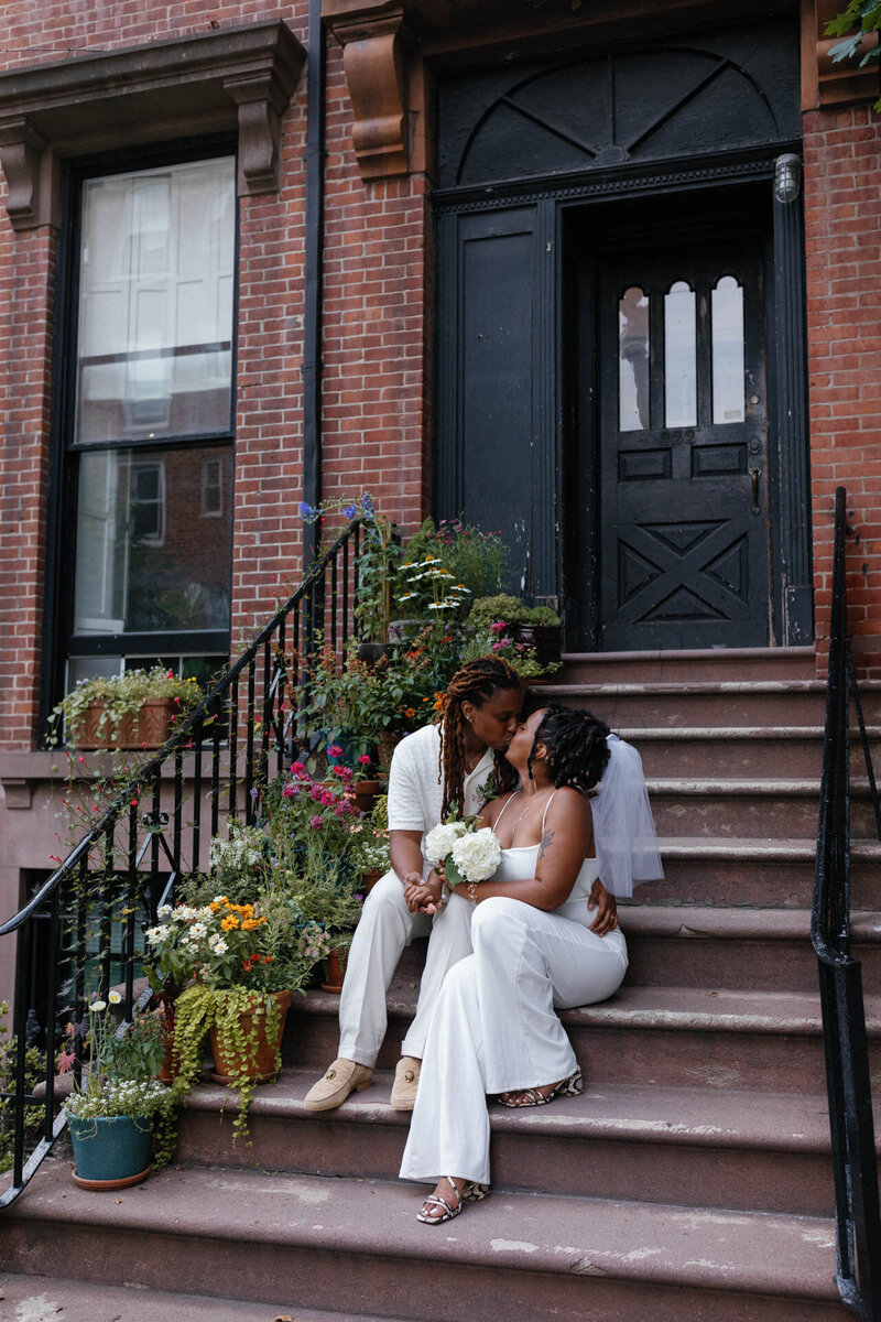 NYC elopement couple in central park kissing with flowers and san remo