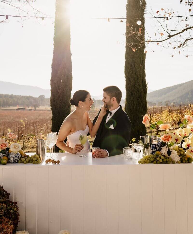 Bride and groom walking along road looking into each others eyes