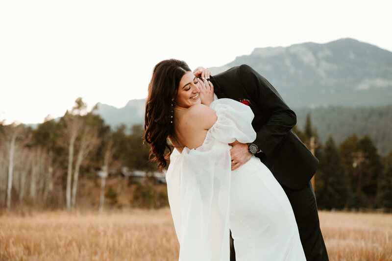 Groom Dipping Bride in Mountain Field