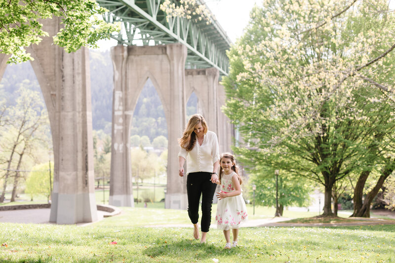 Lisa and her daughter in a park with a blooming tree in the background.