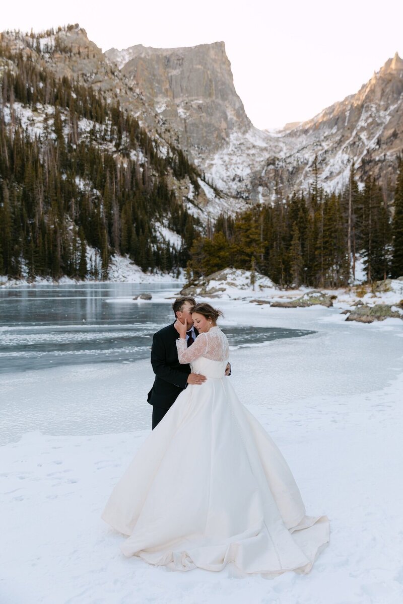 Portrait of a bride and groom on a frozen lake in Rocky Mountain National Park during their Colorado micro wedding