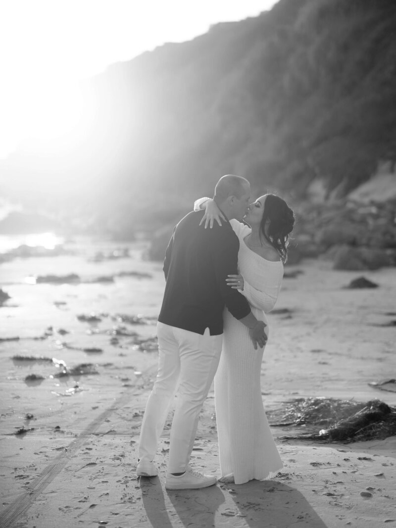Couple taking engagement photos on the beach in Southern California