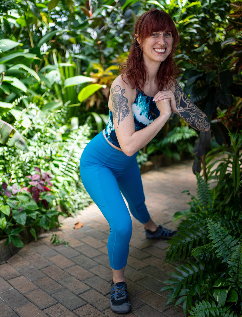 a woman in blue workout clothes does a bodyweight lateral lunge to demonstrate online fitness coaching