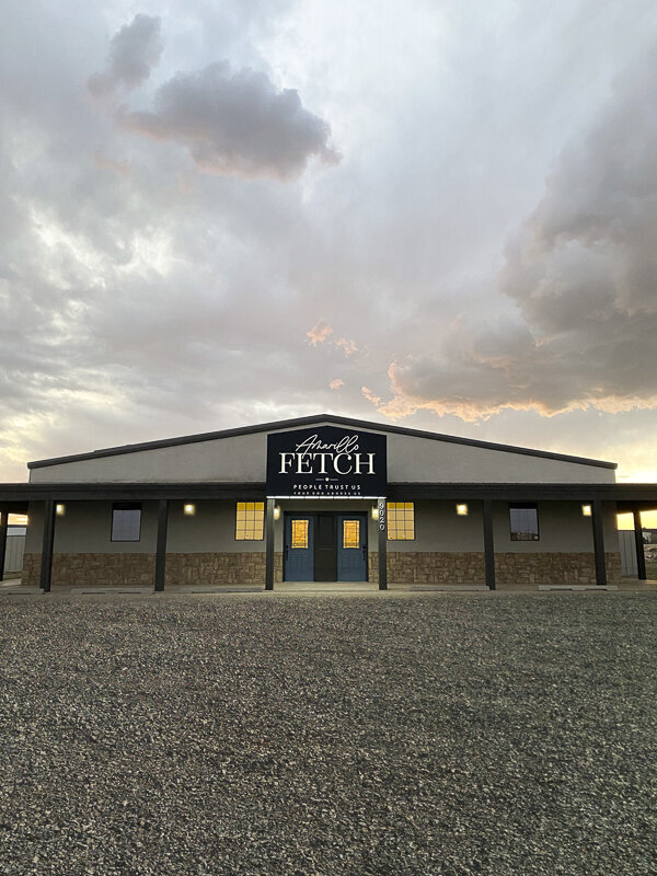 Building is well lit with a sunset and clouds in the background