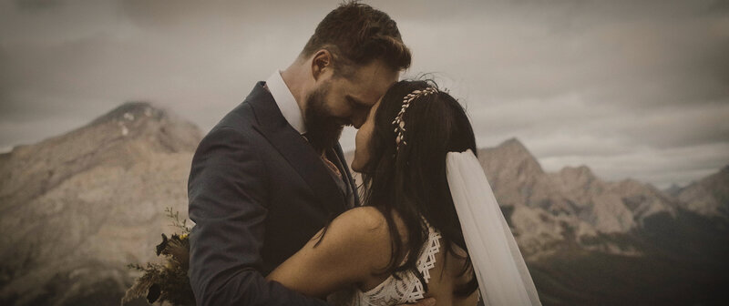 couple sharing a tender moment on their hiking elopement near Canmore alberta at sunrise