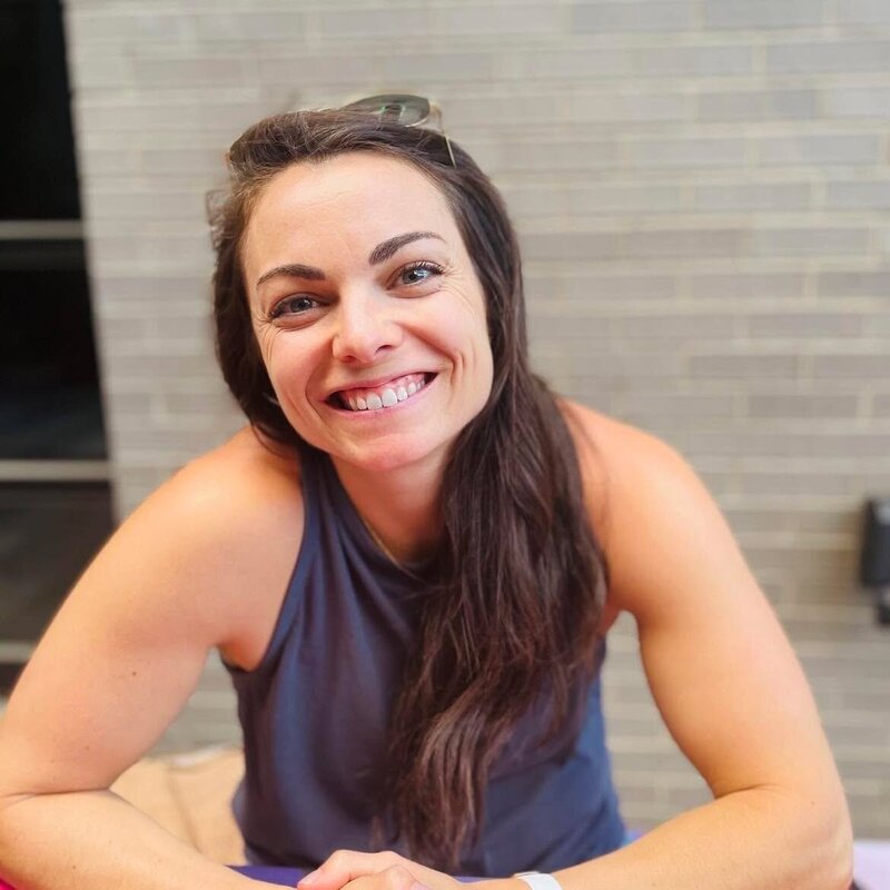 A joyful woman sits at a table, representing the harmony of fitness and nutrition for women's health.