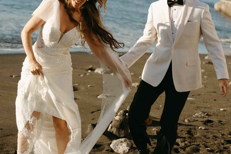 Bride and Groom being playful on a beach in Italy. 