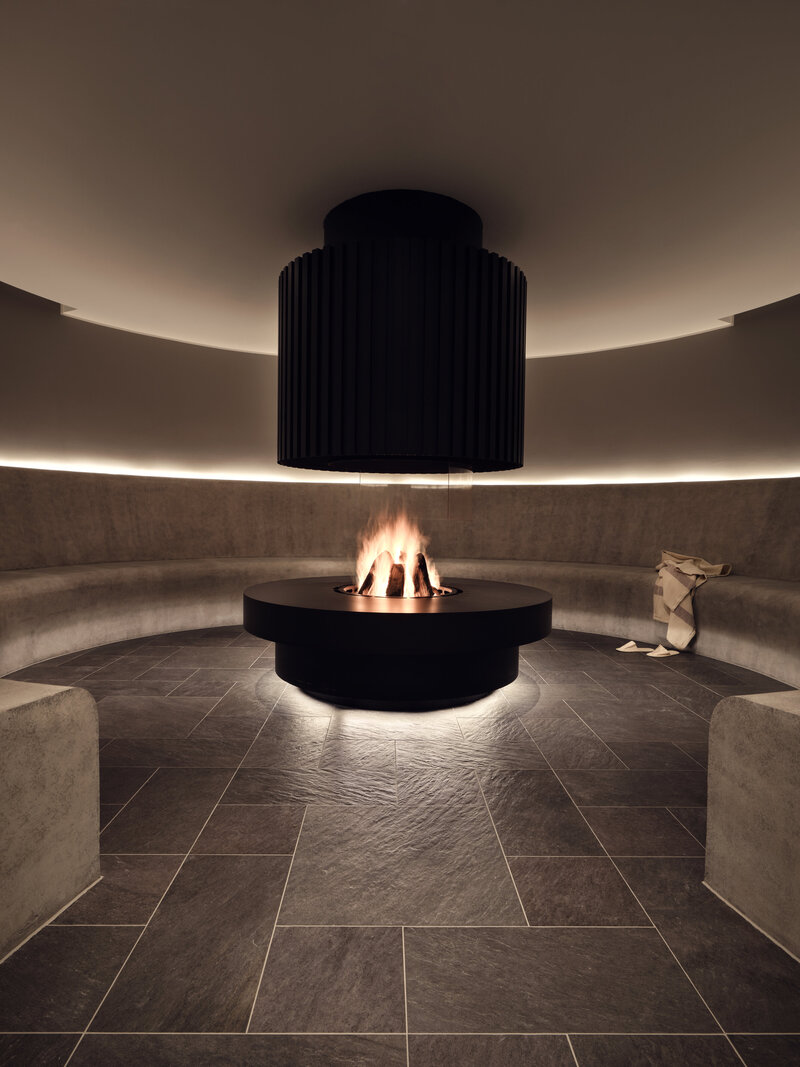 Blick in die steinerne Ruhezone mit offenem Kamin im 639 THE VELA SPA.