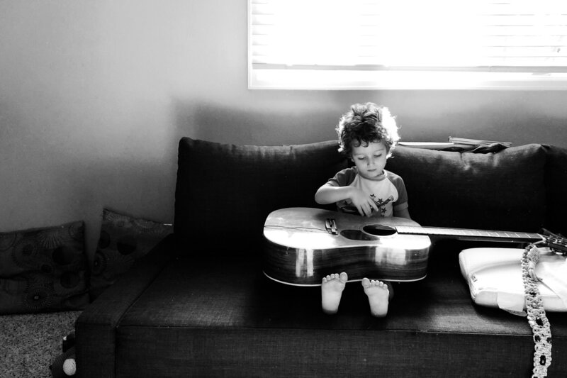Child sitting quietly at a breakfast nook in window light, captured by a hudson valley photographer in Hudson Valley.