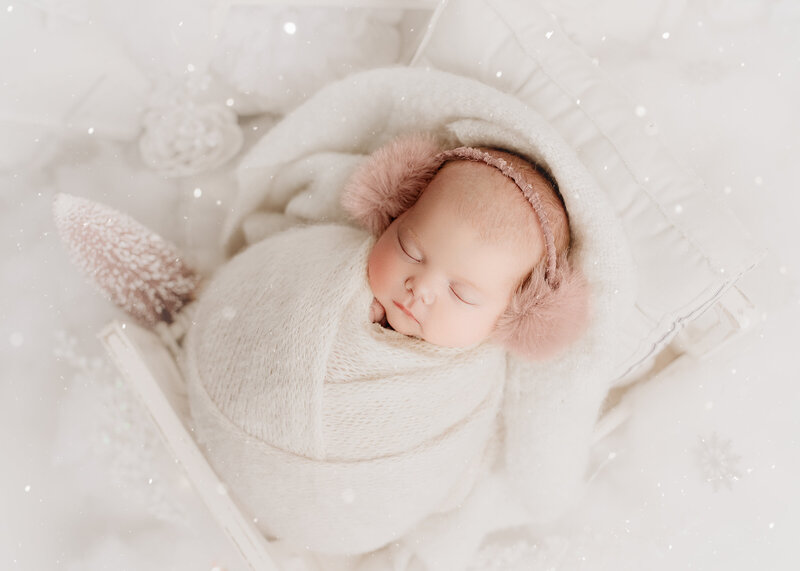 baby in pink and white winter theme with pink tree and white snow