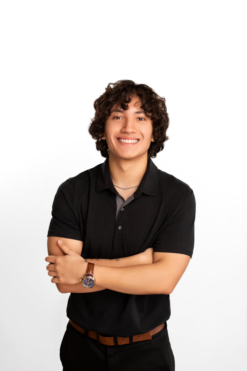 Young man casually poses with his arms crossed for his realtor headshot