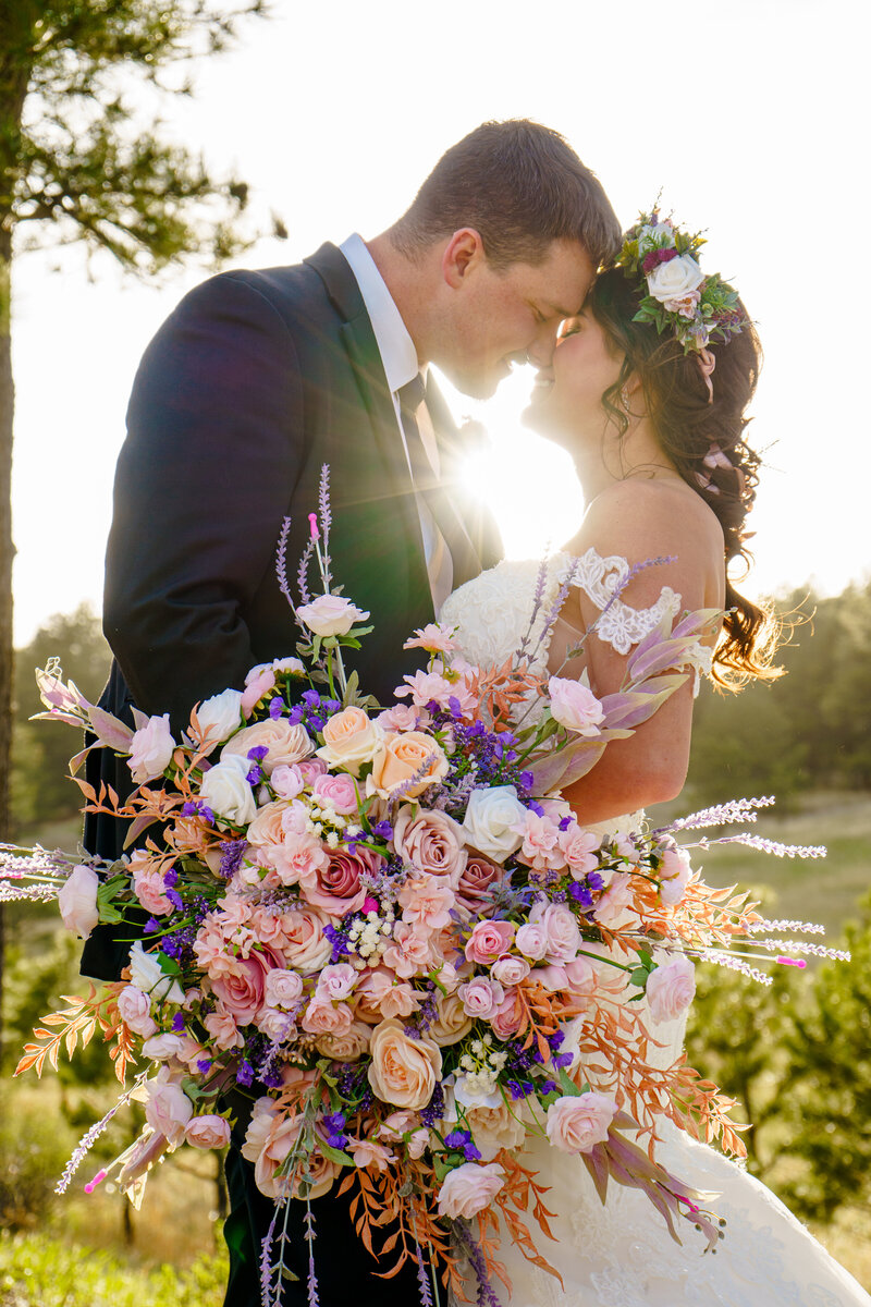 Stunning golden hour couples portrait under a floral umbrella, captured by a creative and romantic Colorado micro-wedding photographer