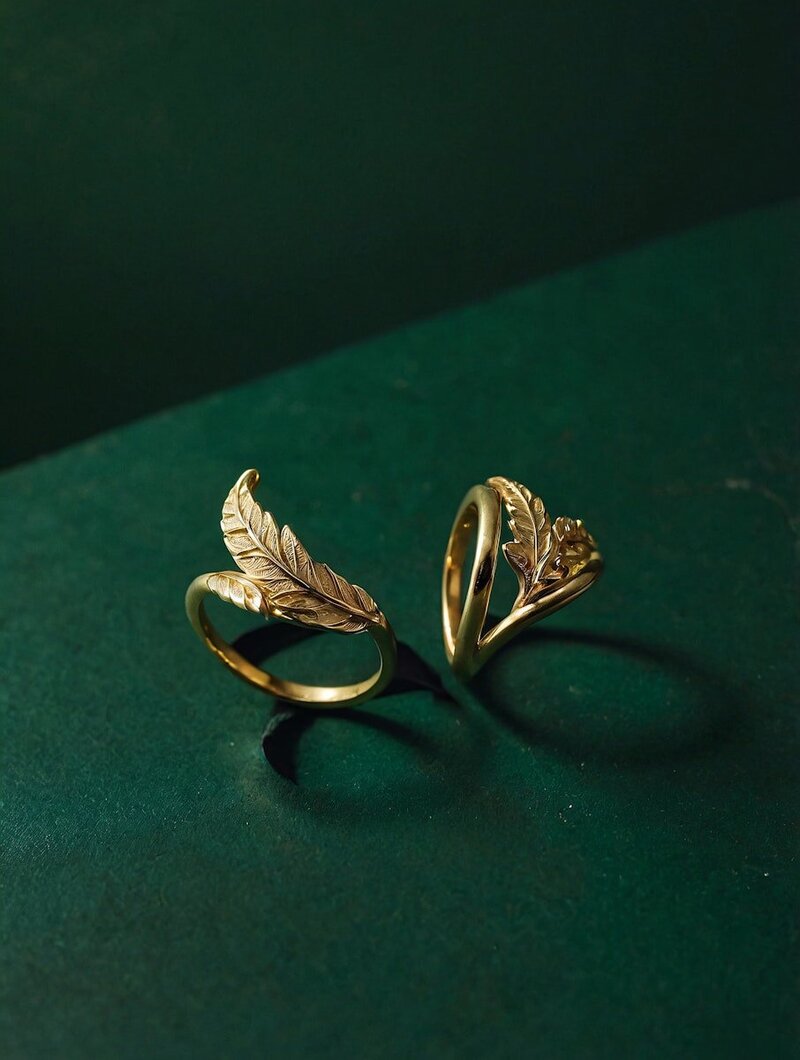 two golden tings with a leaf, on a green background