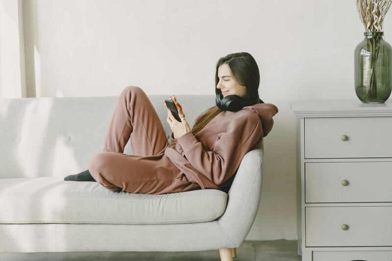 Woman sitting on couch looking at tablet.
