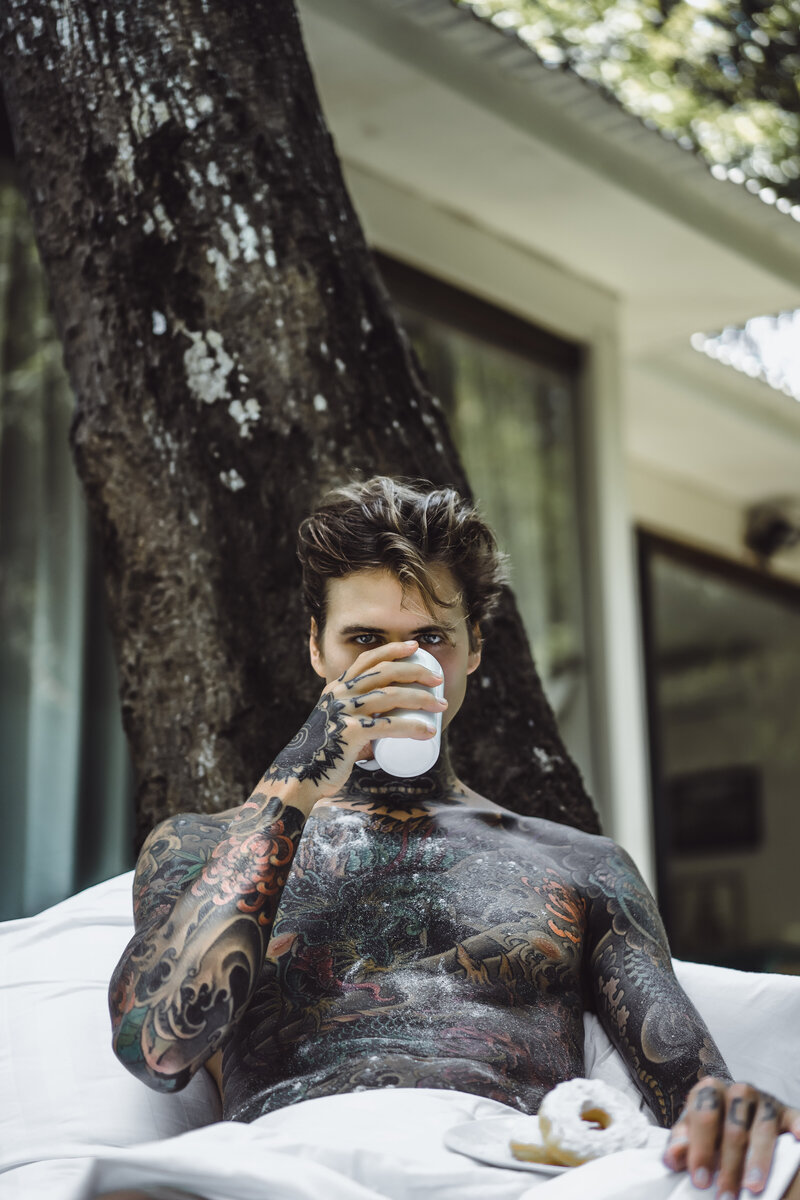 young-handsome-tattooed-man-having-breakfast-bed-open-air-outdoors-garden