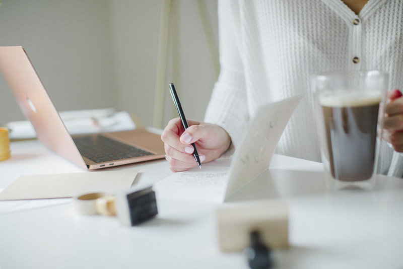 virtual brand manager for travel pros working at desk writing notes