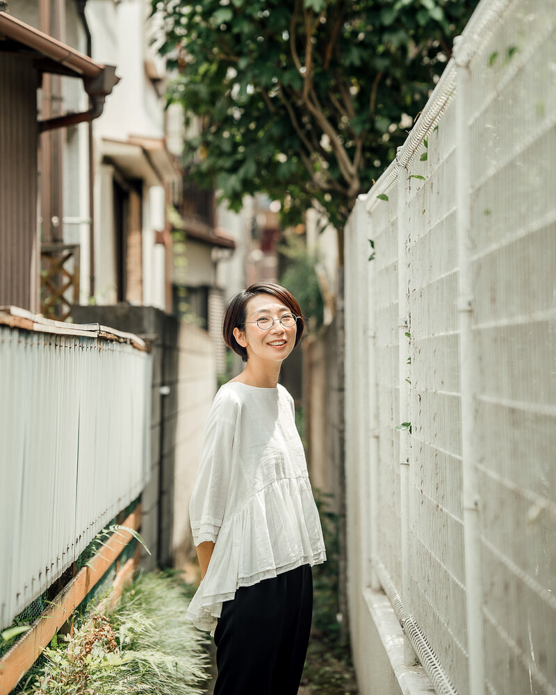 Photographer Miho Iimura on the street wearing white shirt