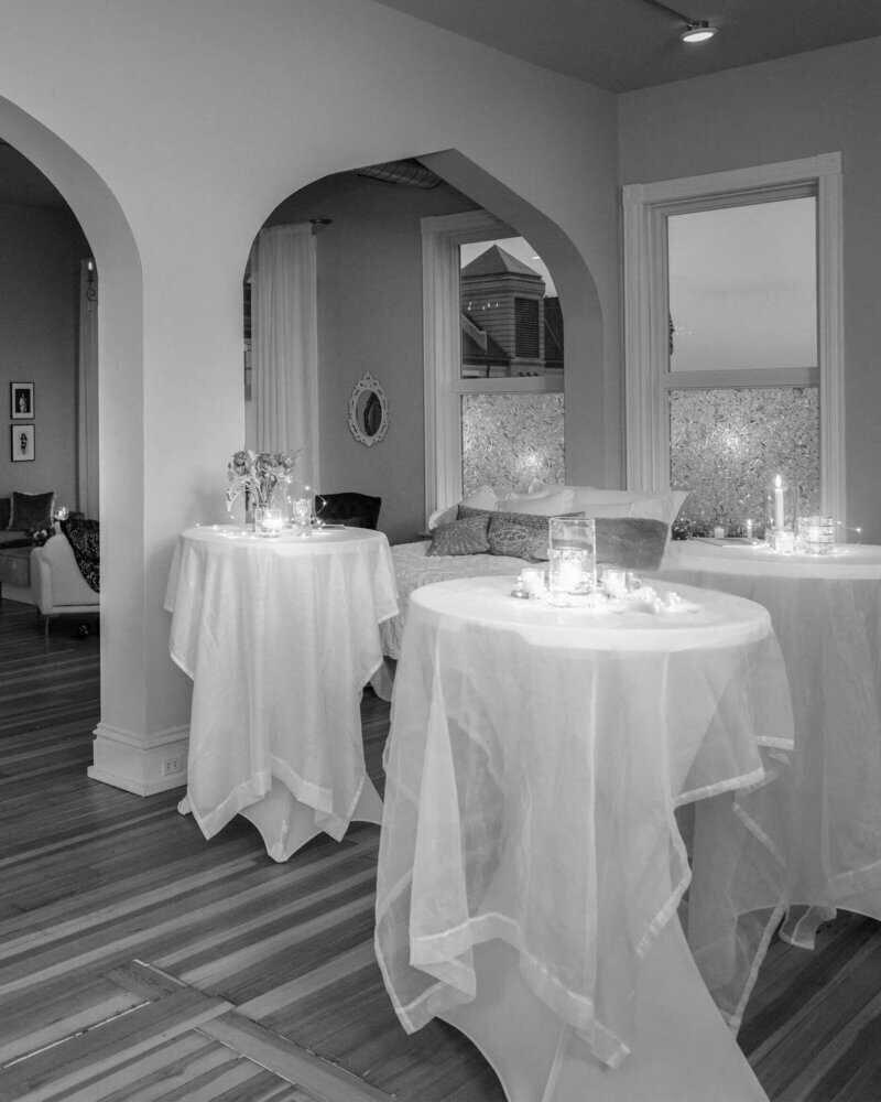 Elegant event space with softly lit tables and draped décor.