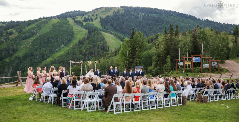Large wedding ceremony set up on Thunderhead Lawn with mountain ski run backdrop at Steamboat Springs Ski Resort in Colorado