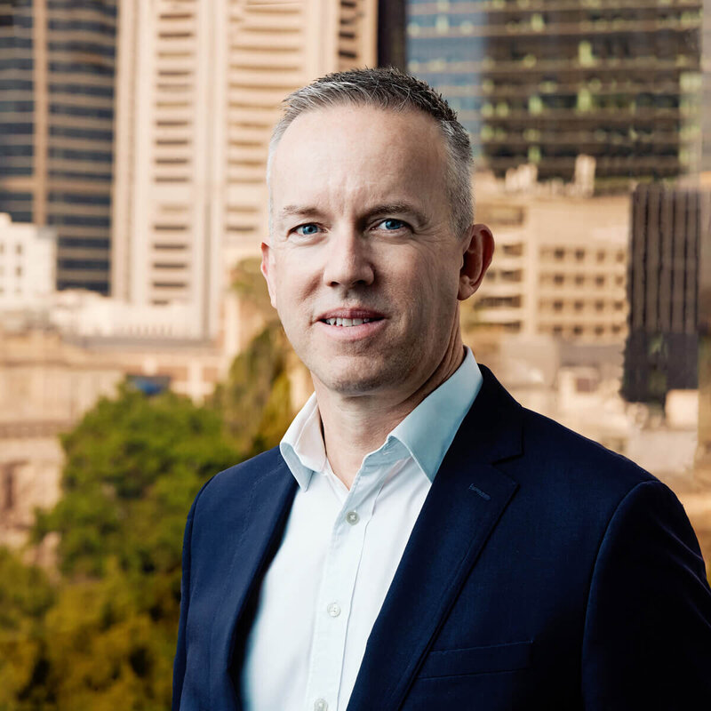 CEO with Melbourne cityscape behind him.