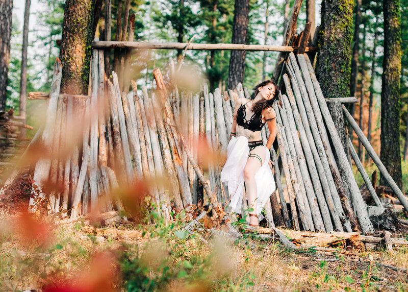 Outdoor boudoir woman in black lingerie posing on structure in Pattee Canyon, Missoula